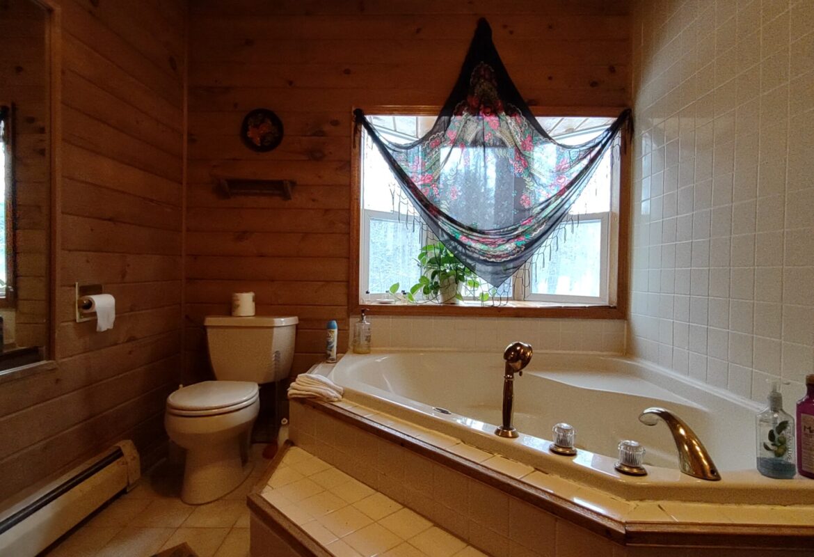 jacuzzi bathroom with large window covered by Russian scarf