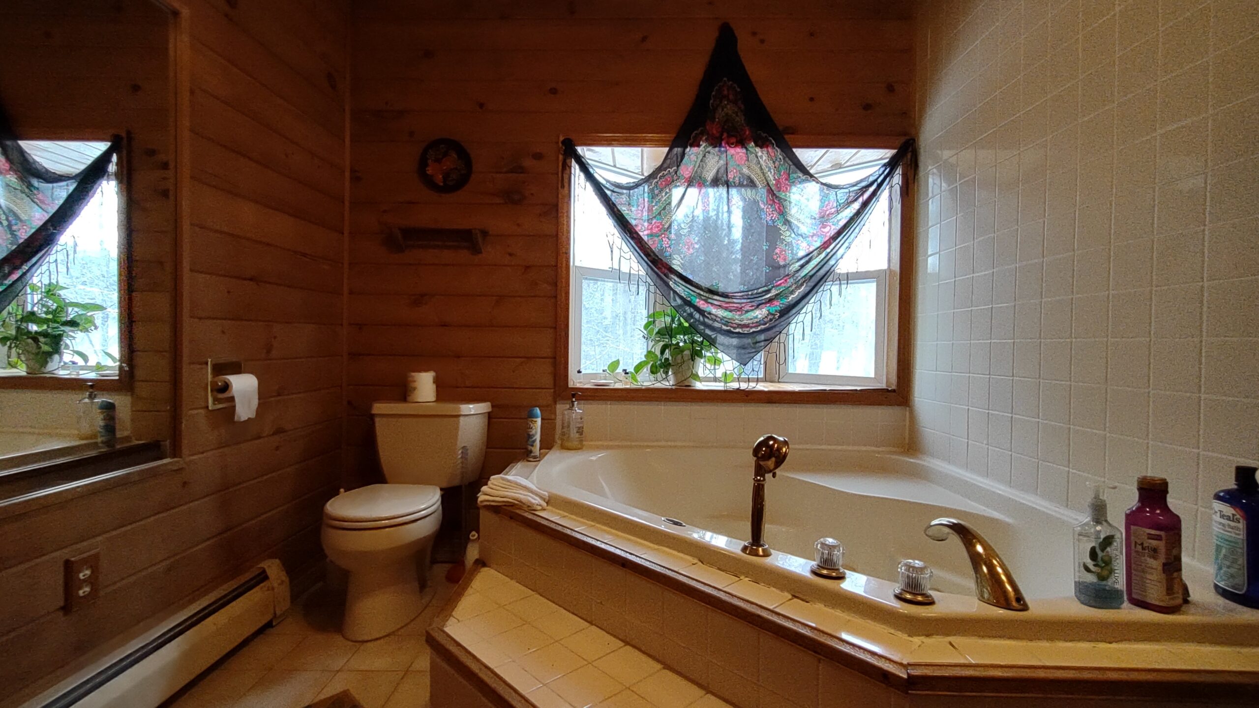 jacuzzi bathroom with large window covered by Russian scarf